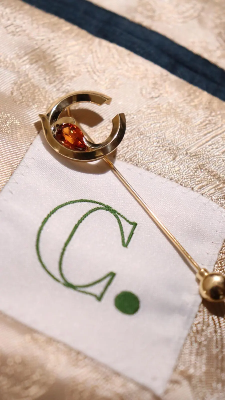 Épingle en or sertie d'une pierre orange, réalisation Oro et Baud